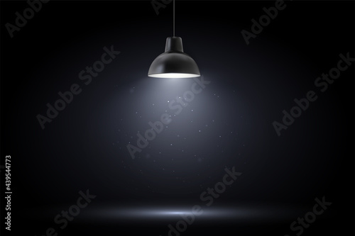 Lamp in dark room. Spotlight on black background. Place for text or product presentation.