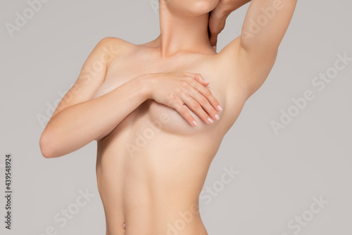 Cropped portrait of young, slim, healthy and beautiful woman isolated over gray background.