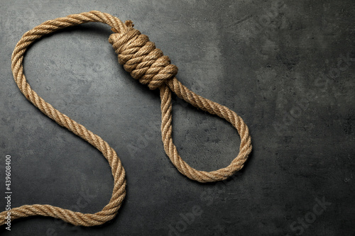 Rope noose with knot on grey table, top view. Space for text