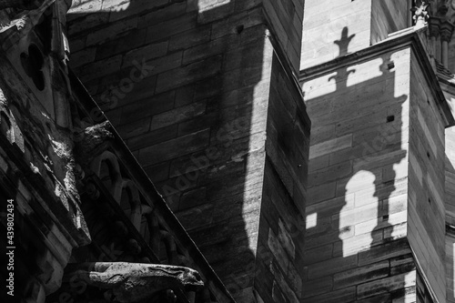 Slow travel in Paris - discovering the little things: Black and white image of shadow and light painting on the buttresses of a gothic cathedral