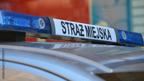 Znak straż miejska na dachu radiowozu polskiej policji.