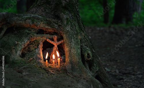 witchcraft doll and candles on natural forest dark background. Forest grandmother, defender guardian spirit of nature. ancient pagan, Wiccan, Slavic traditions. Magic, esoteric spiritual ritual