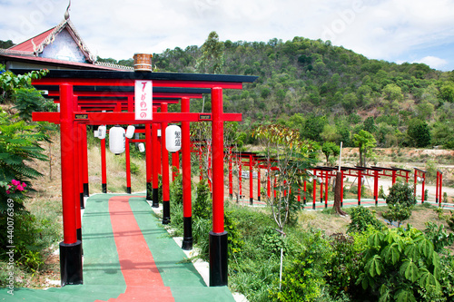 Red torii gate of Wat Khao Sung Chaem Fa temple on Khao Sam Sip Hap mountain for thai people and foreign travelers travel visit and respect praying at Tha Maka on May 23, 2021 Kanchanaburi, Thailand