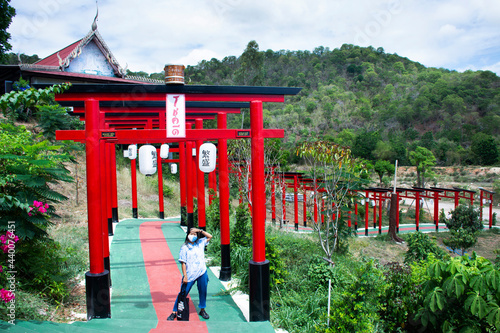 Asian travelers thai women travel visit posing portrait with Red torii gate of Wat Khao Sung Chaem Fa temple on Khao Sam Sip Hap mountain at Tha Maka district on May 23, 2021 Kanchanaburi, Thailand