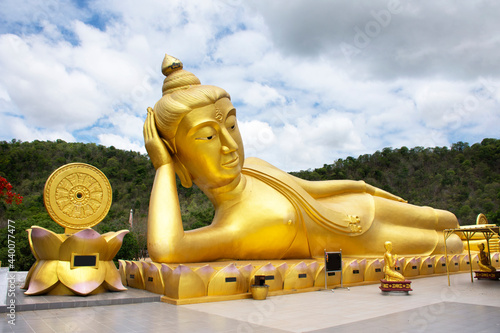 Buddha reclining attitude statue of Wat Khao Sung Chaem Fa temple on Khao Sam Sip Hap mountain for thai people foreign travelers travel visit and respect praying at Tha Maka in Kanchanaburi, Thailand