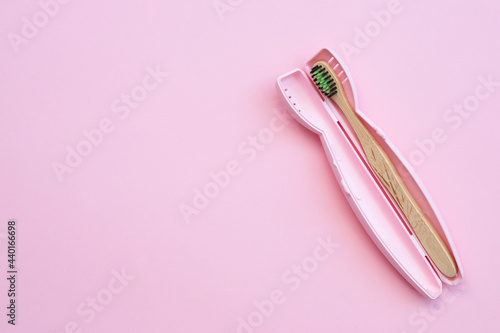 Toothbrush in a plastic case on pink background