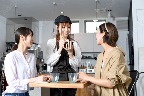 飲食店で働くエプロン姿の女性が注文を取るイメージ