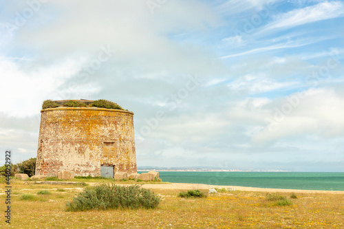 Martello tower on the beach with copyspace, blue sky
