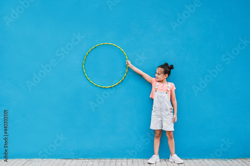 Cute little girl holding hula hoop ring - Child having playful time in the city