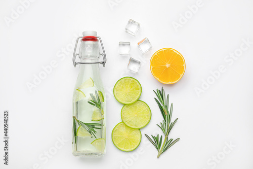 Composition with bottle of healthy lemonade and citrus fruits on white background