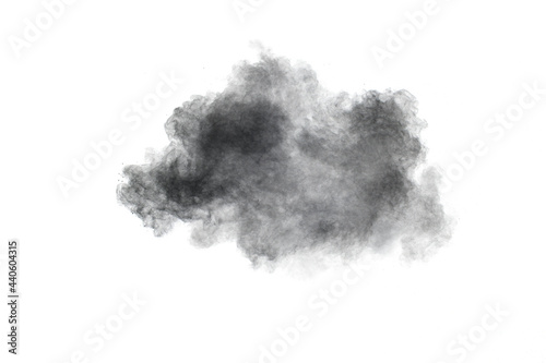 Black powder exploding.The particles of charcoal splash on white background.