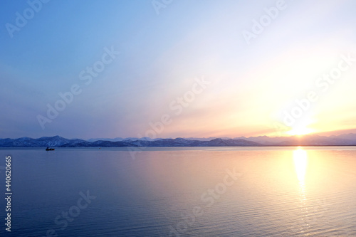 Sunset view of the Avacha Bay. Ships standing in the roadstead, mountains in the background. Petropavlovsk-Kamchatsky, Kamchatka Peninsula, Russia.