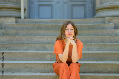 Woman sitting waiting patiently on a flight of steps