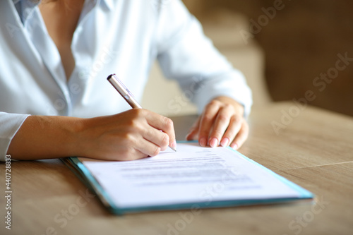 Close up of woman hands signing contract on table