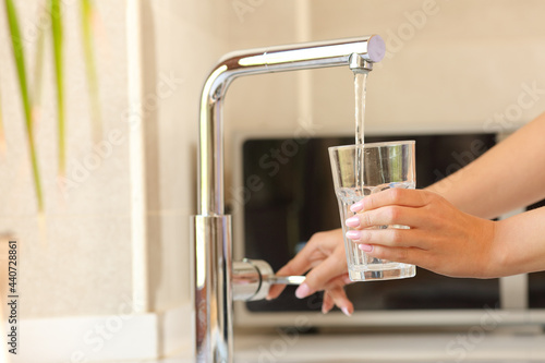 Woman hands filling a glass of tap water