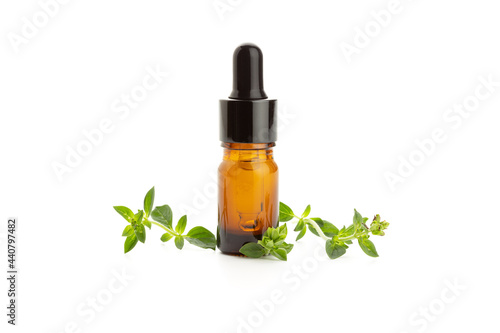Oregano essential oil and fresh oregano leaves isolated on white background. Origanum vulgare oil