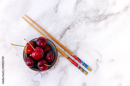 bowl of cherries on marble background and wicker tablecloth