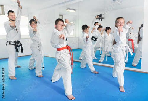 Children trying new martial moves in a practice during a karate class in gym