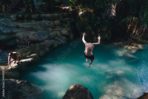 Man jumping into a natural pond