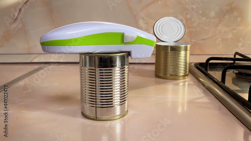 Electric can opener and canned goods on kitchen table