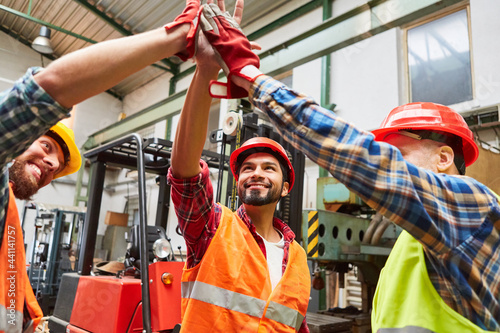 Lagerarbeiter in Lagerhalle machen High Five zur Motivation