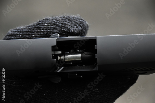 Closeup view of 9mm automatic pistol chamber which is holding in hand, selective and soft focus.