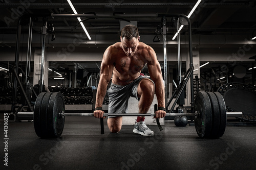 Athlete, man doing deadlift with a barbell young athlete preparing for a heavy weight barbell lifting workout