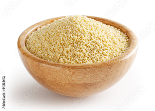 Uncooked dried couscous in wooden bowl isolated on white background with clipping path