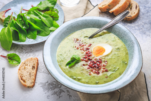 Creamy sorrel soup with egg and bacon bits