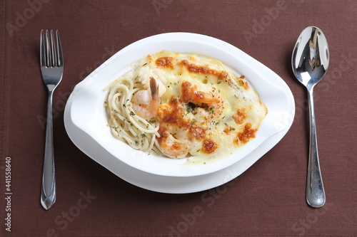 oven baked creamy cheese cabonala pasta with fresh big prawn in bowl western chef cuisine seafood menu in white and brown background