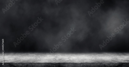 Empty space of Studio dark room with concrete floor grunge texture background and white smoke.