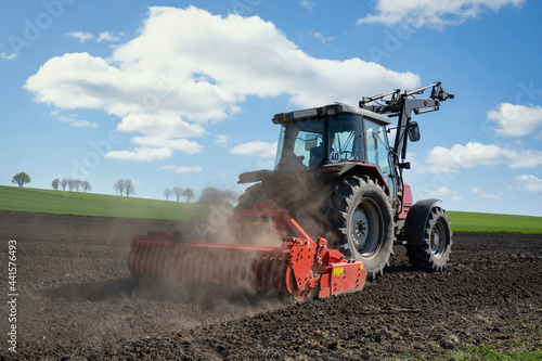 Agrarmotiv - Ackerbau Traktor und angehängte Kreiselegge auf einem Acker.