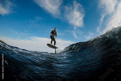 Beautiful view of man riding on the wave with hydrofoil foilboard