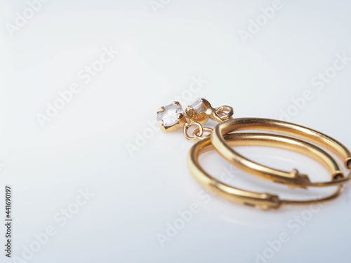 Close up shoot of a pair of golden earrings with diamonds