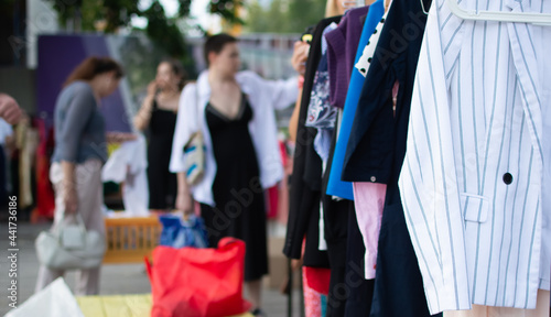 display of second hand clothes on rack for charity,donation,reusing or reselling for second life sold at garage sale for fashion fans or economic shopping