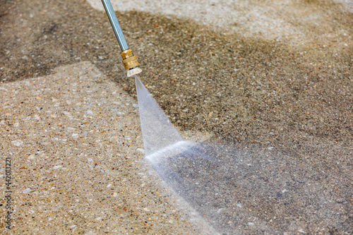 Pressure washing concrete driveway. Home cleaning, maintenance and household chores concept