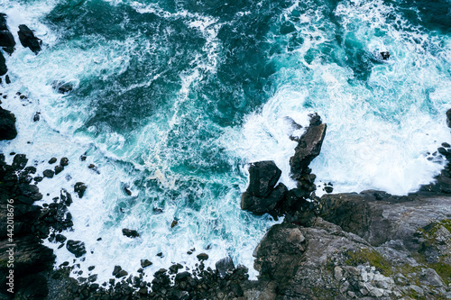 Aerial shot of waves from the Atlantic crashing on cliffs on the West Coast of Ireland 