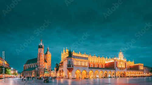 Krakow, Poland. Evening Night View Of St. Mary's Basilica And Cloth Hall Building. Famous Old Landmark Church Of Our Lady Assumed Into Heaven. UNESCO World Heritage Site