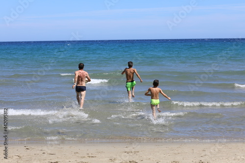 Tata i synowie podczas wygłupów na plaży. Dad and sons on the beach.