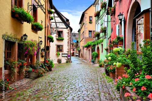 Quaint colorful cobblestone lane in the Alsatian town of Riquewihr, France