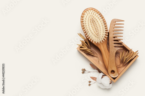 Box with hair brush and comb on color background