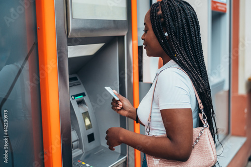 African american woman using atm machine and a credit card