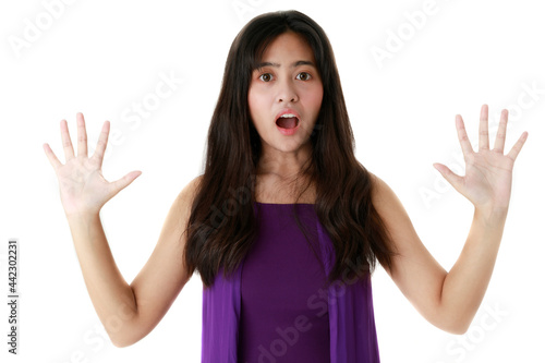 Frightened ethnic female with opened mouth looking at camera on white background in studio