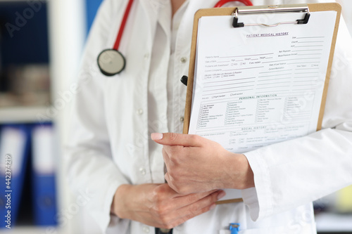 Doctor holds clipboard with the patient medical history