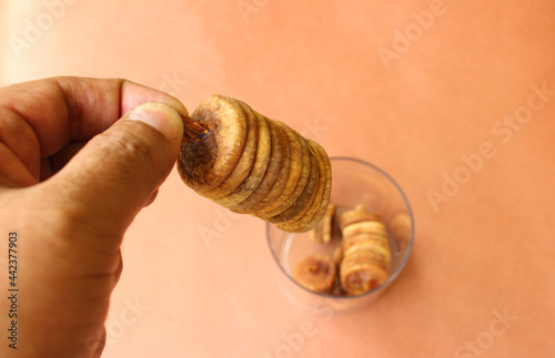 Hand holding a stack of dry figs or anjeer fruit