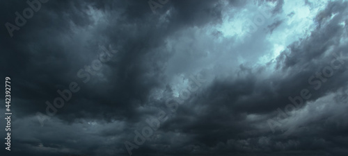 The dark sky had clouds gathered to the left and a strong storm before it rained.Bad or moody weather sky.