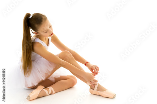 Girl ballerina puts on pointe shoes. The concept of dancing.