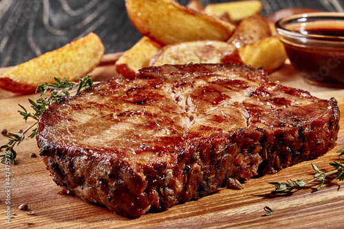 Fried pork steak with potato wedges and barbecue sauce