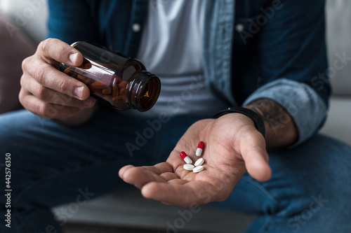 Handful of white pills in male patients palm. Healthcare, treatment, drugs and depression, pain and suicide