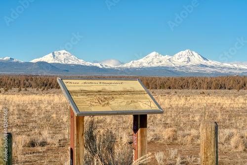 Three Sisters Mountains in Oregon with an informational sign
